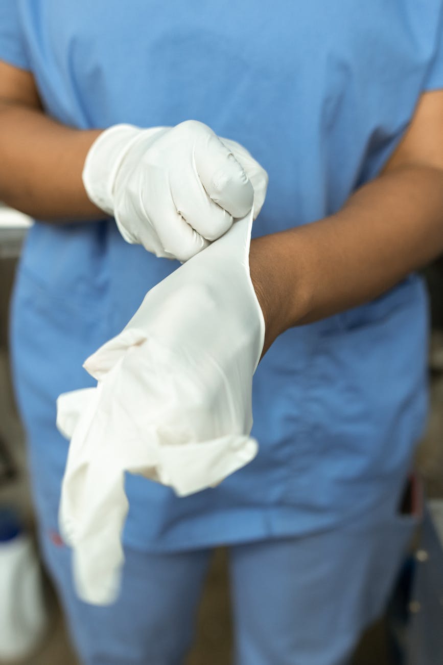 person in blue scrub suit holding white textile